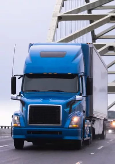 Blue truck driving over bridge